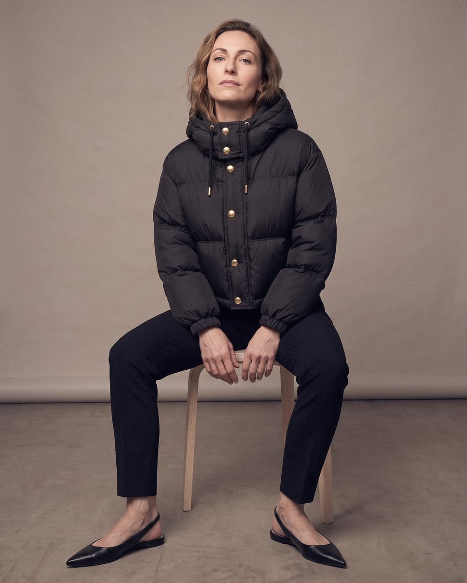 Doudoune courte à capuche, noir, porté, assise penchée en avant