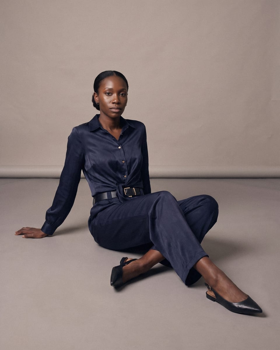 Ensemble chemise et pantalon ceinturé, bleu marine, porté, assise au sol, jambes allongées