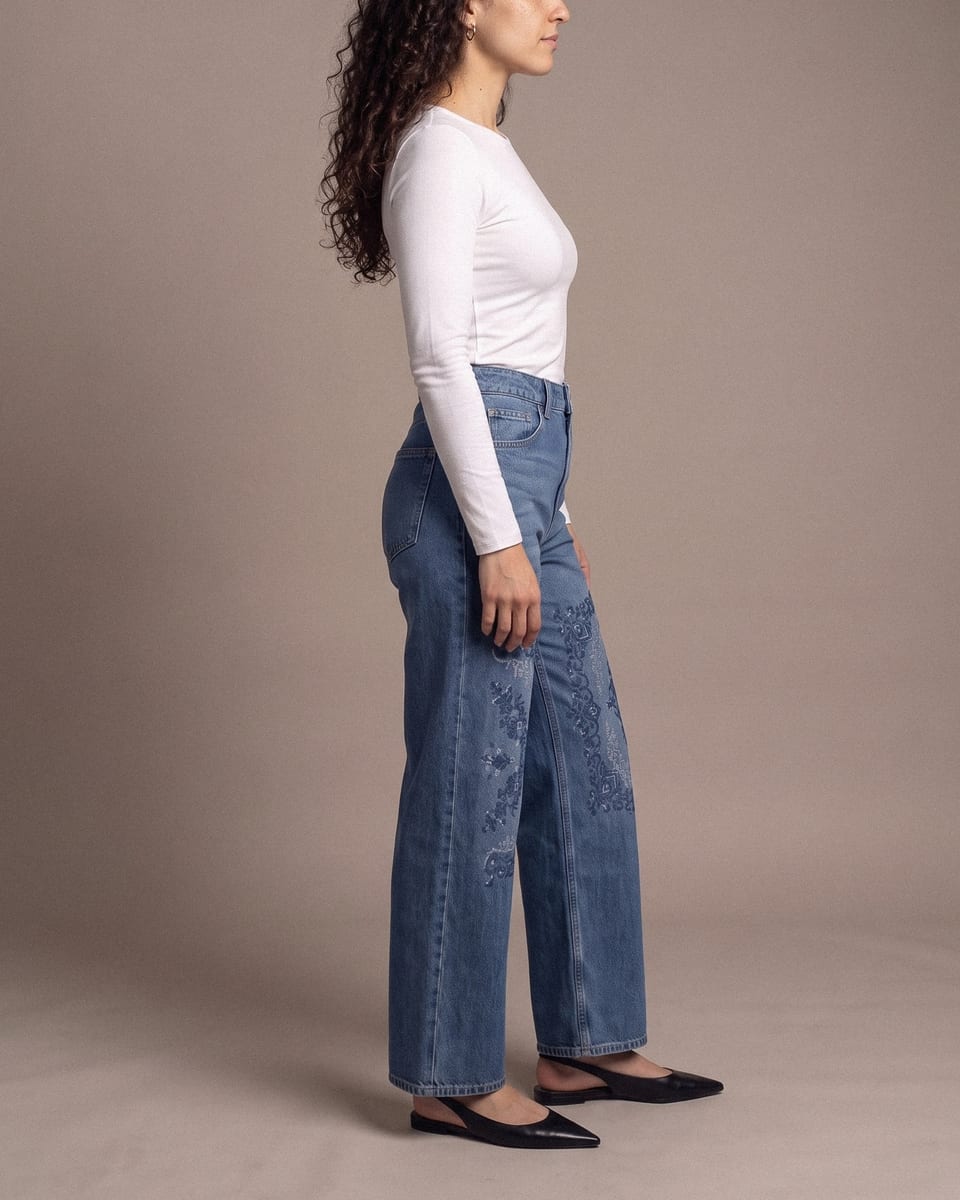 Jean large brodé, bleu, porté, encolure, tête de profil