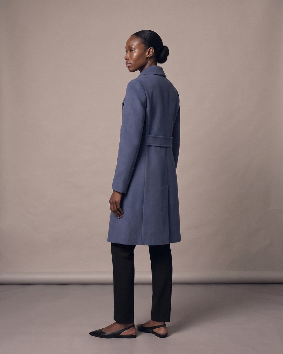Manteau croisé ceinturé, bleu, porté, trois-quarts dos, visage de profil