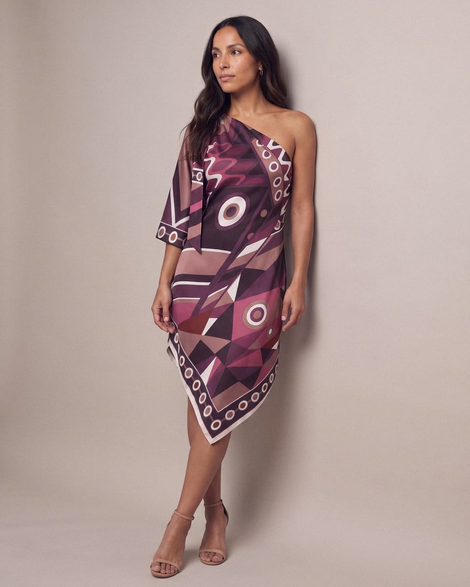 Robe asymétrique foulard, prune, portée, appuyée au mur, chevilles croisées