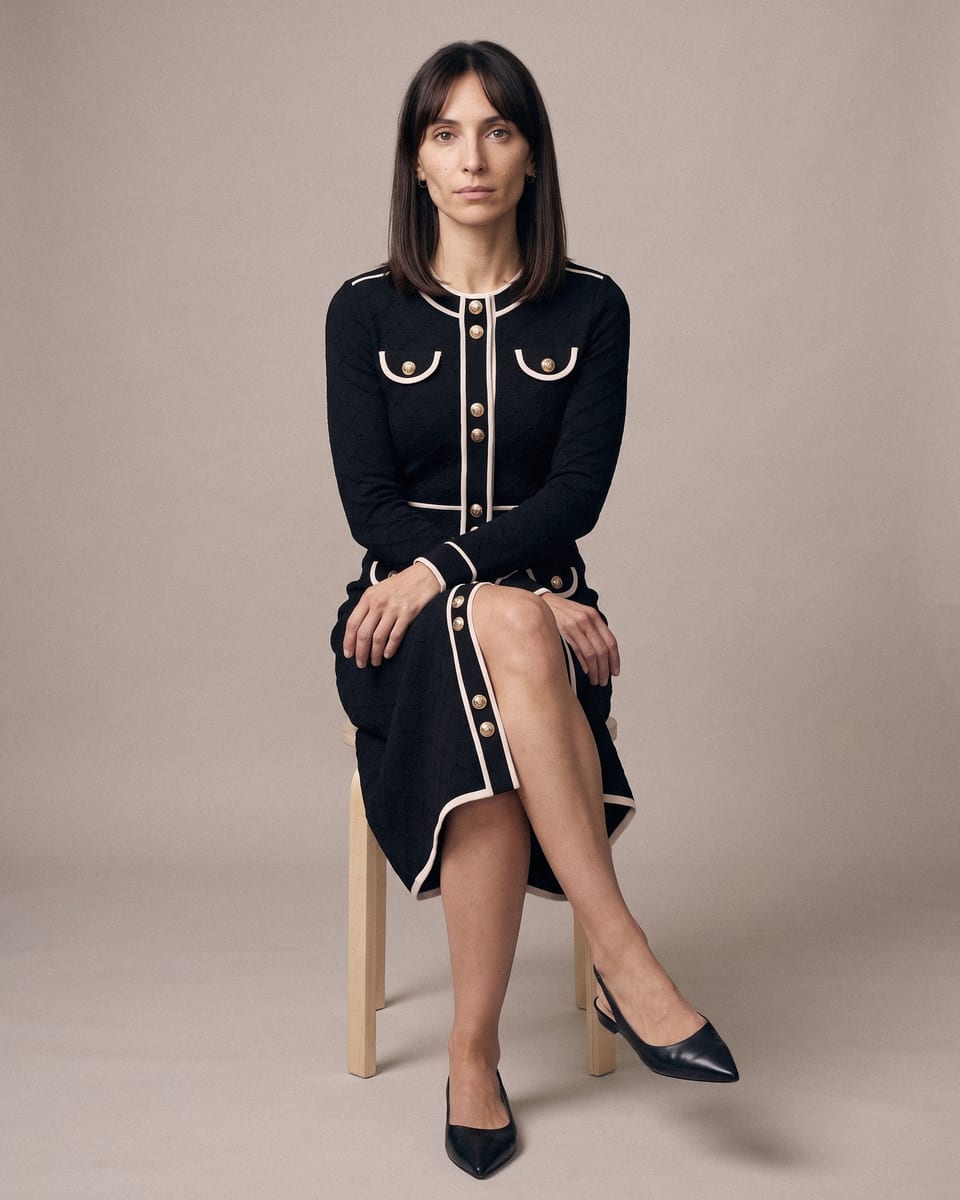 Robe passepoilée à boutons, noir, portée, assise sur tabouret, jambes croisées