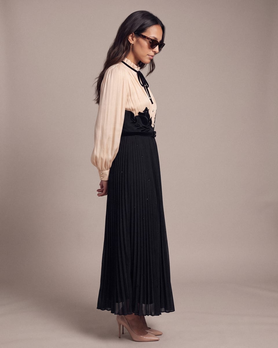 Robe plissée, ivoire et noir, portée, profil, tête baissée