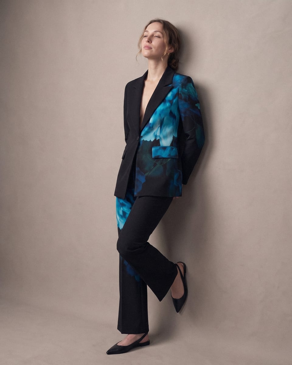 Tailleur fleurs bleues, noir, porté, dos contre le mur, tête relevée